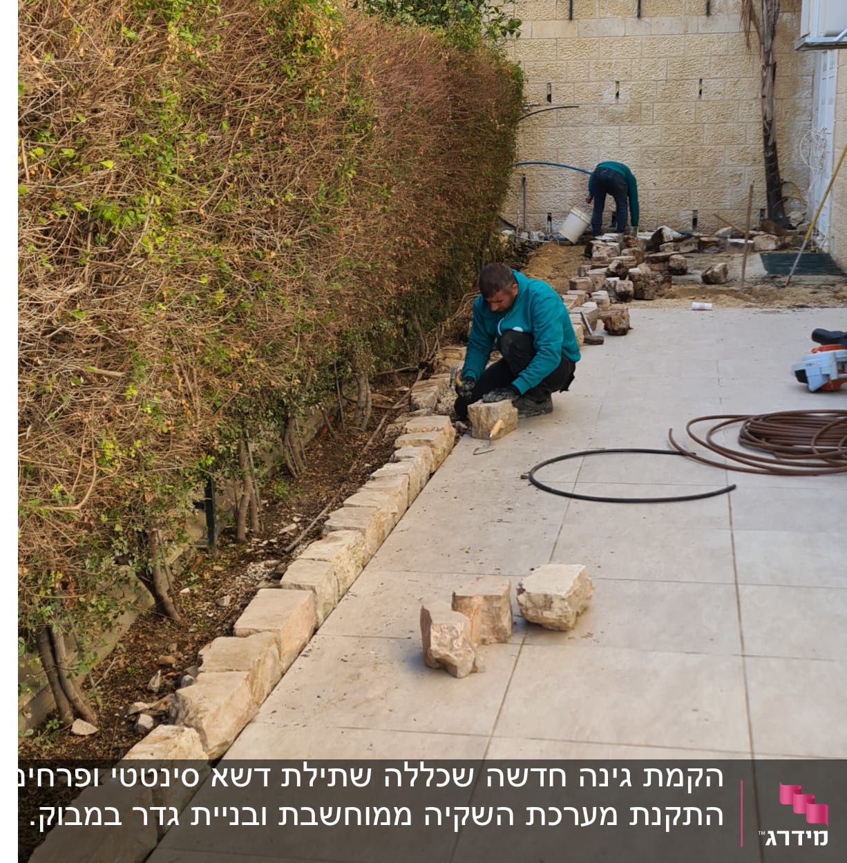 שני אנשים עובדים בגינה, מניחים אבנים לאורך שביל